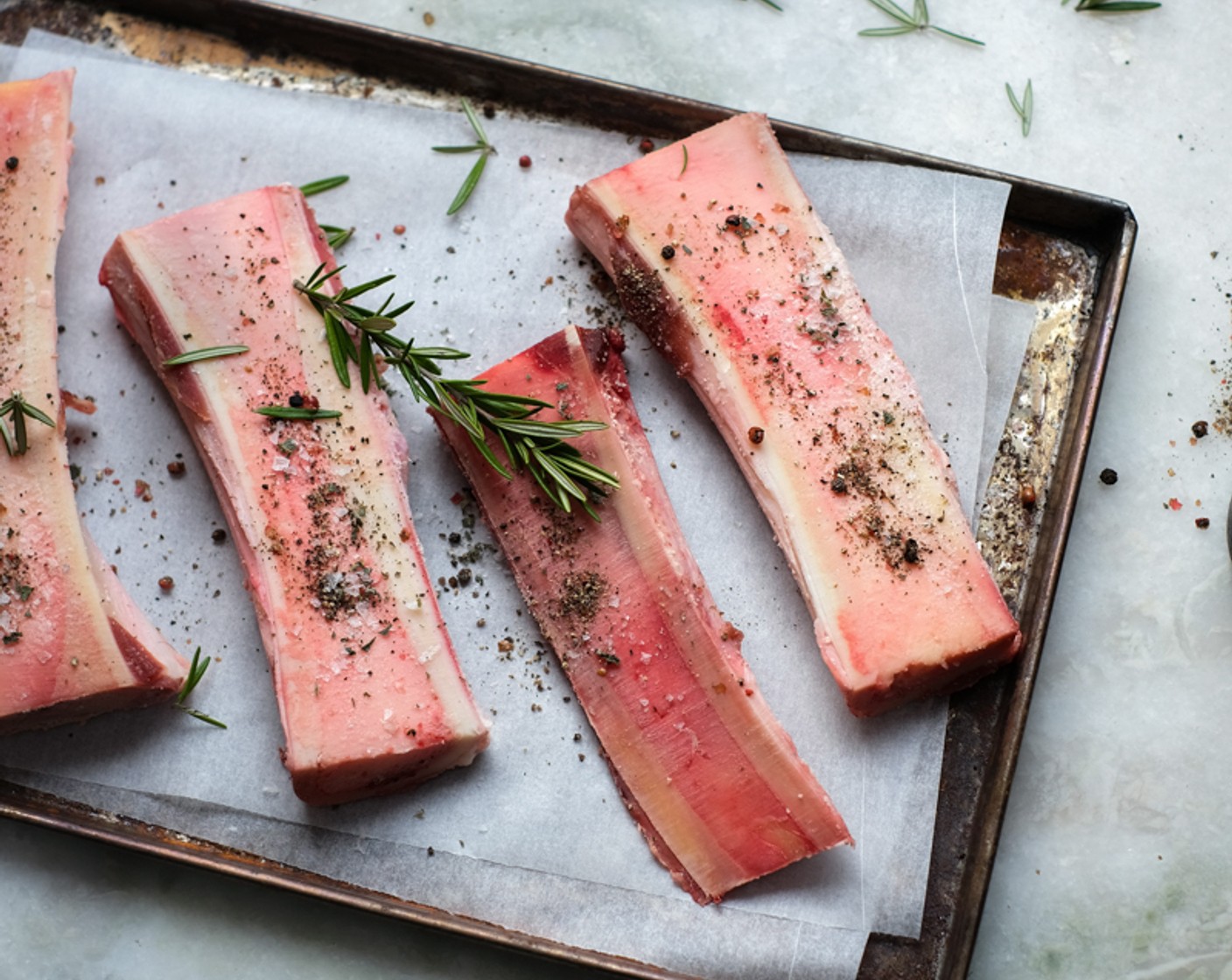 step 14 Arrange the Beef Marrow Bones (8) on a lined baking sheet and season with Coarse Sea Salt (to taste), Ground Black Pepper (as needed), and Fresh Thyme (4 sprigs).