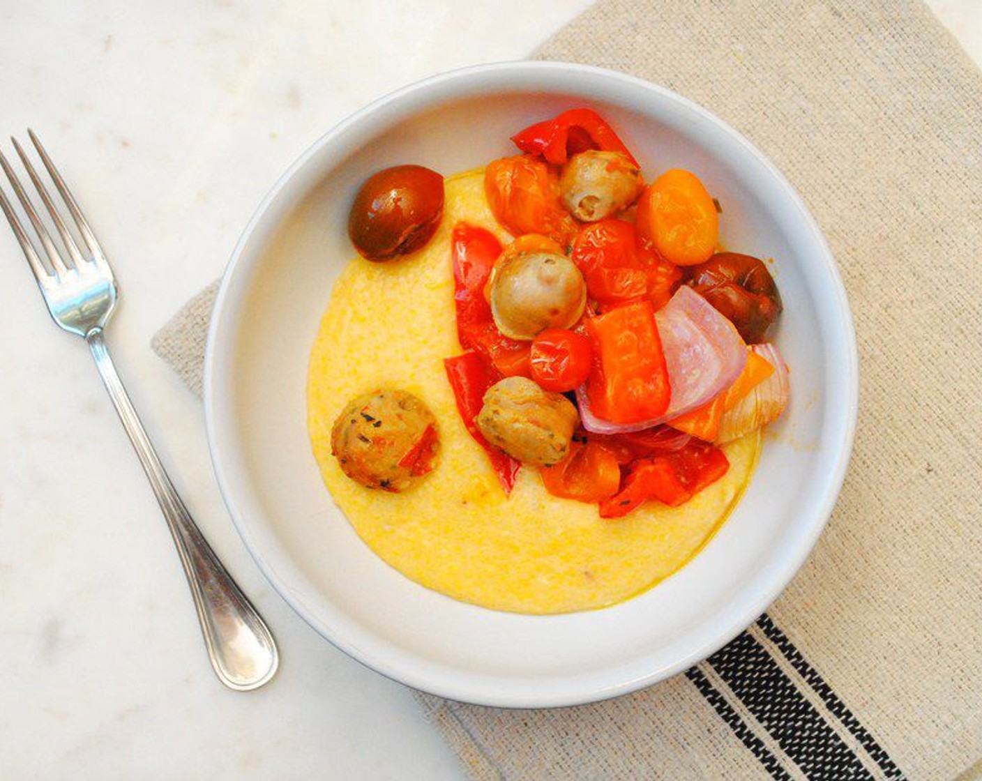 step 8 Spoon the polenta onto individual plates and then top with the sausage and peppers.