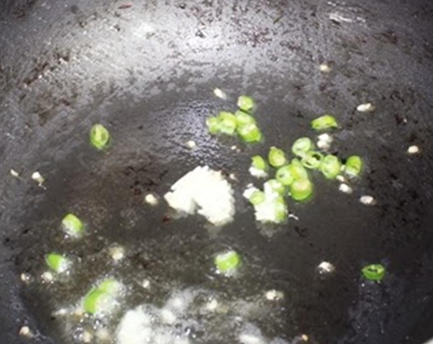 step 7 In the same pan add the Green Chili Peppers (4), Garlic (3 cloves), and Fresh Ginger (1 Tbsp) and fry for 10 seconds.