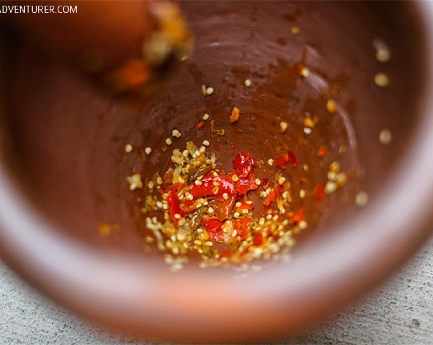 step 1 In the clay mortar and pestle, mash the Thai Chili Peppers (2) and Garlic (1 clove).