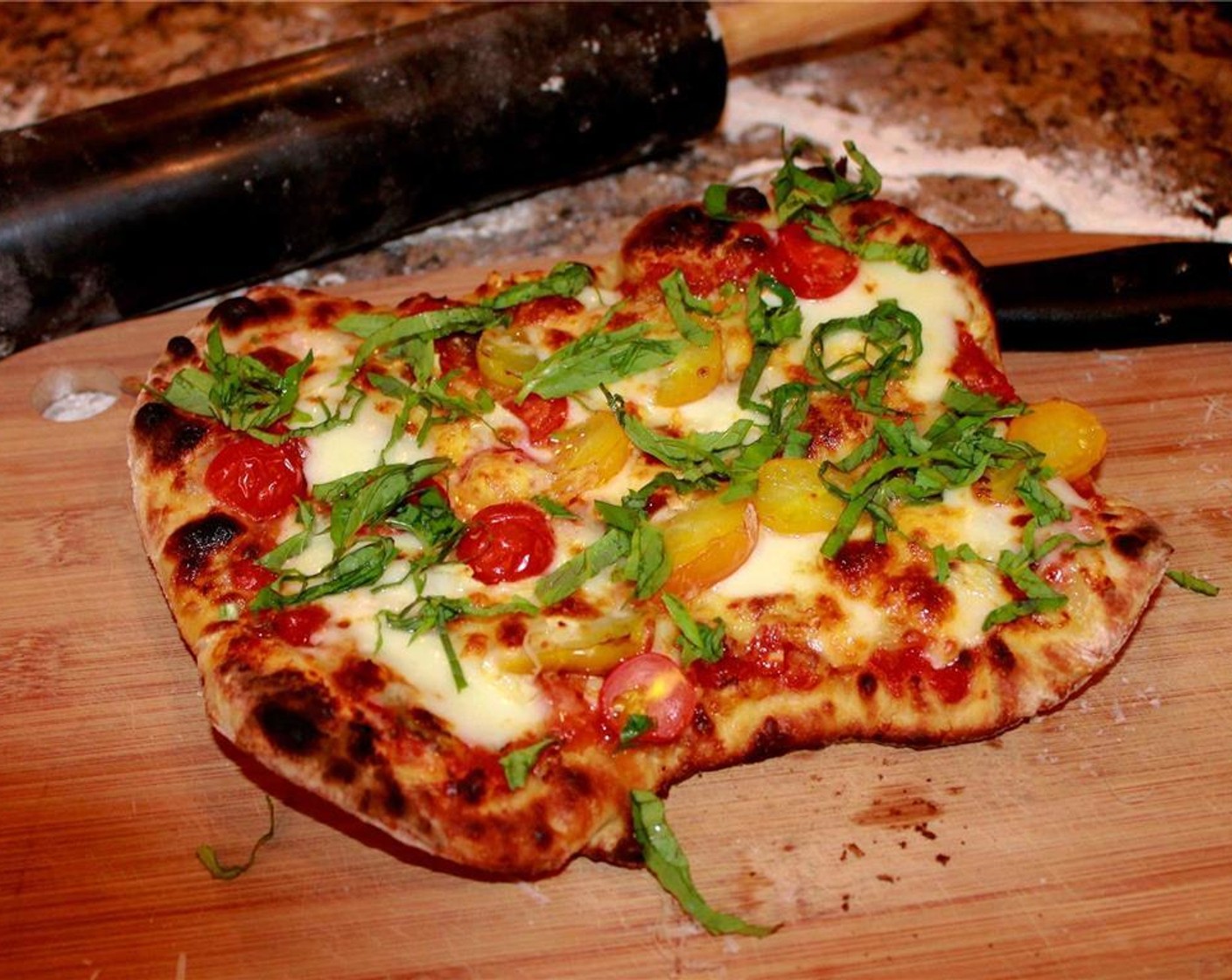 step 16 Remove the pizza from the oven. Slide the pizza onto a cutting board or plate. Garnish with fresh basil leaves, and allow to cool for 2 minutes. Repeat the process with the other half of the dough.