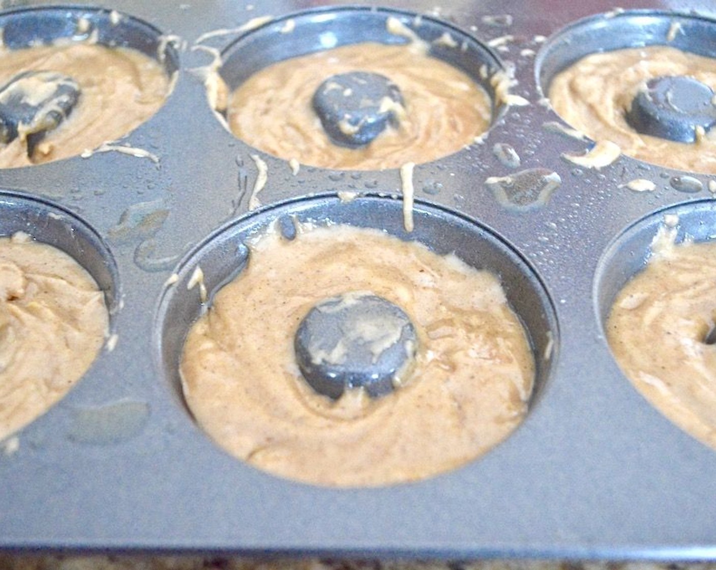 step 5 Scoop the batter into a piping bag and pipe the batter evenly in the donut pan, filling each one about halfway.