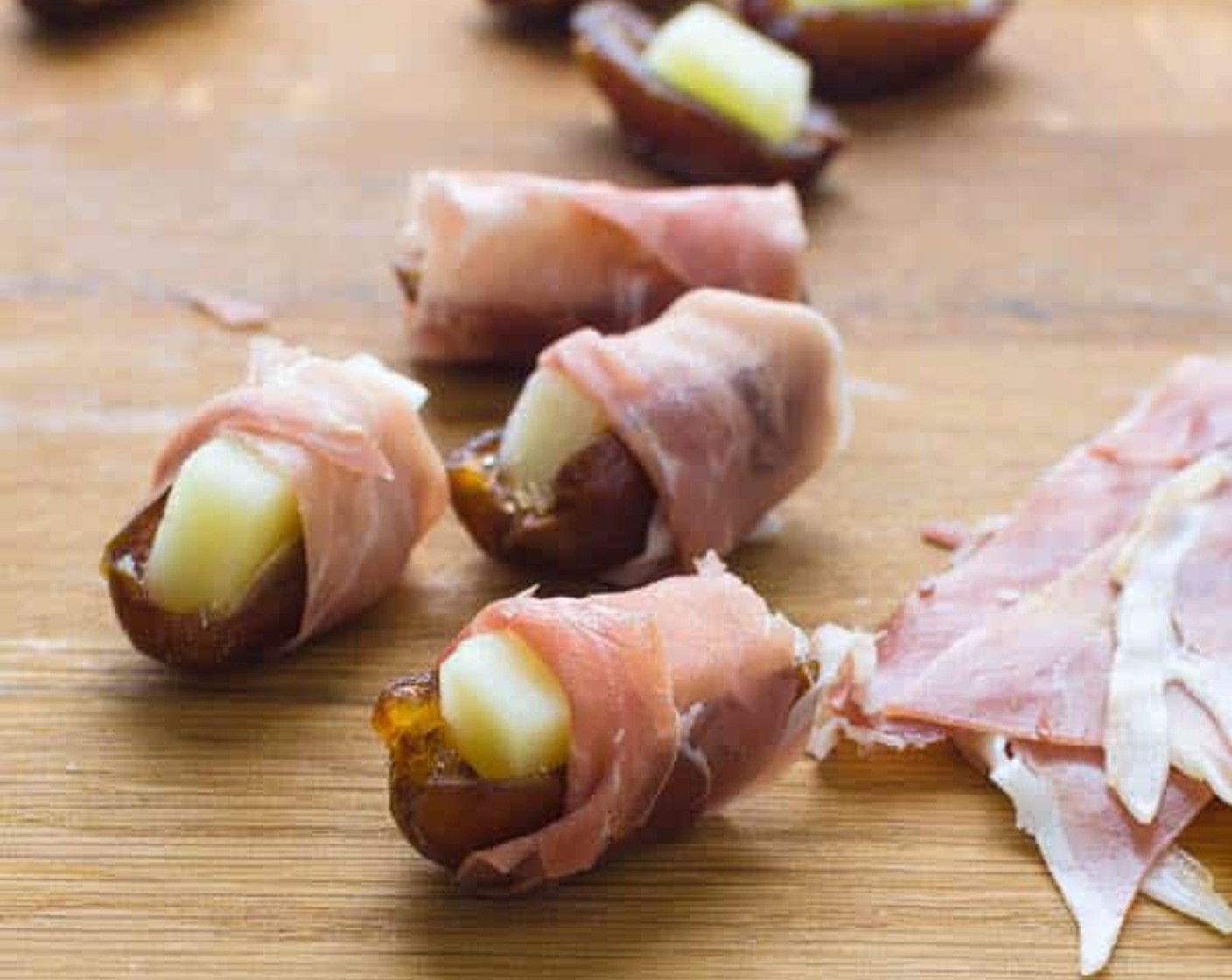 step 4 Roll Prosciutto di Parma (5 slices) around the date crosswise a few times and transfer to a baking sheet. Repeat for the rest of the dates.