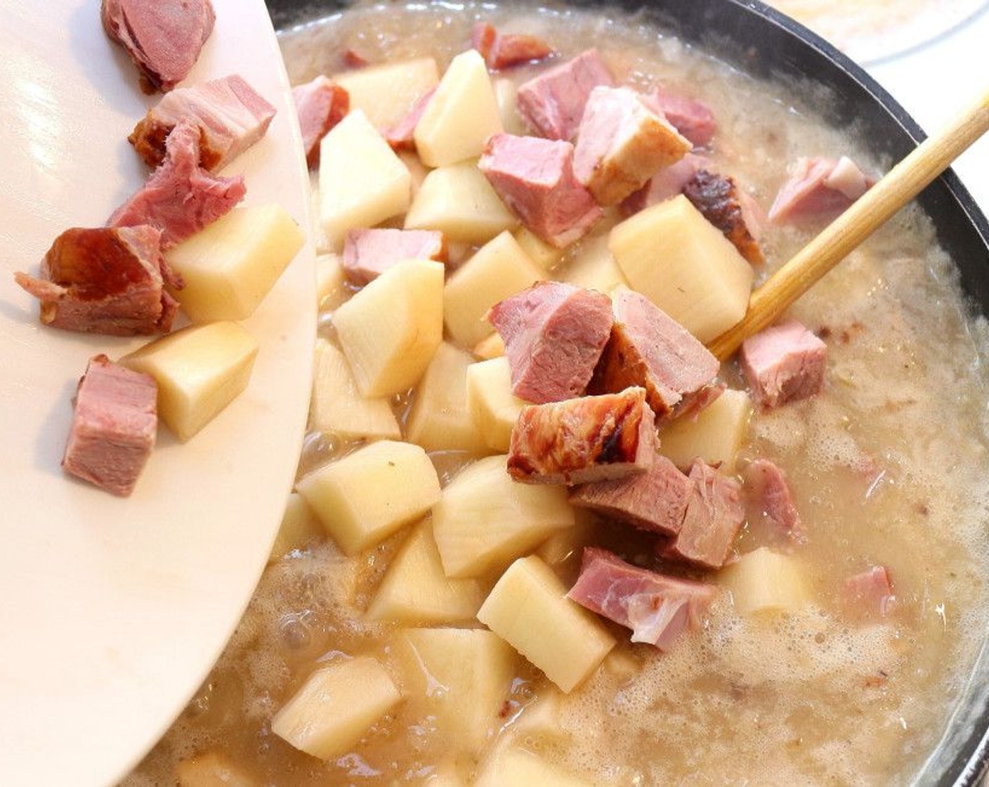 step 7 Add the Diced Ham Hock and Diced Potato to the pot. Season with Kosher Salt (to taste), Cayenne Pepper (to taste), and Maggi Seasoning (1 dash). Bring to a simmer again, and simmer for 20 minutes or until potatoes are soft but not mushy.