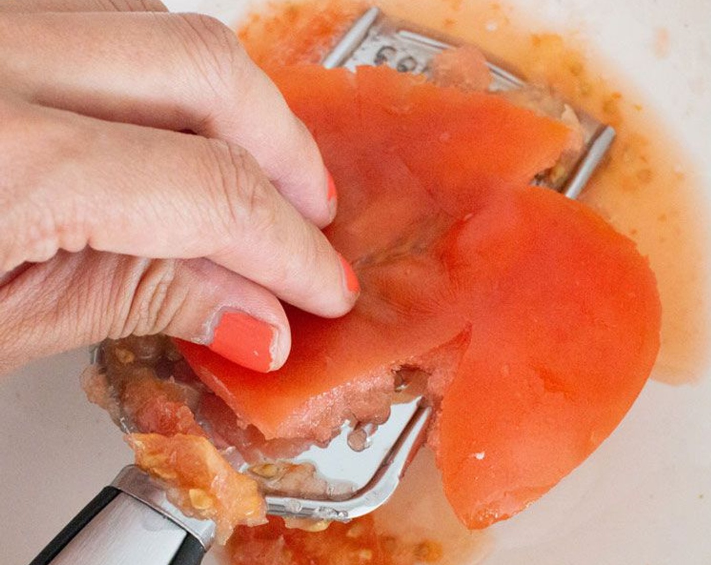 step 2 Meanwhile, over a large bowl, use the largest holes on a grater to grate the Tomato (1) and discard the skin, season with Salt (1/4 tsp) and set aside.