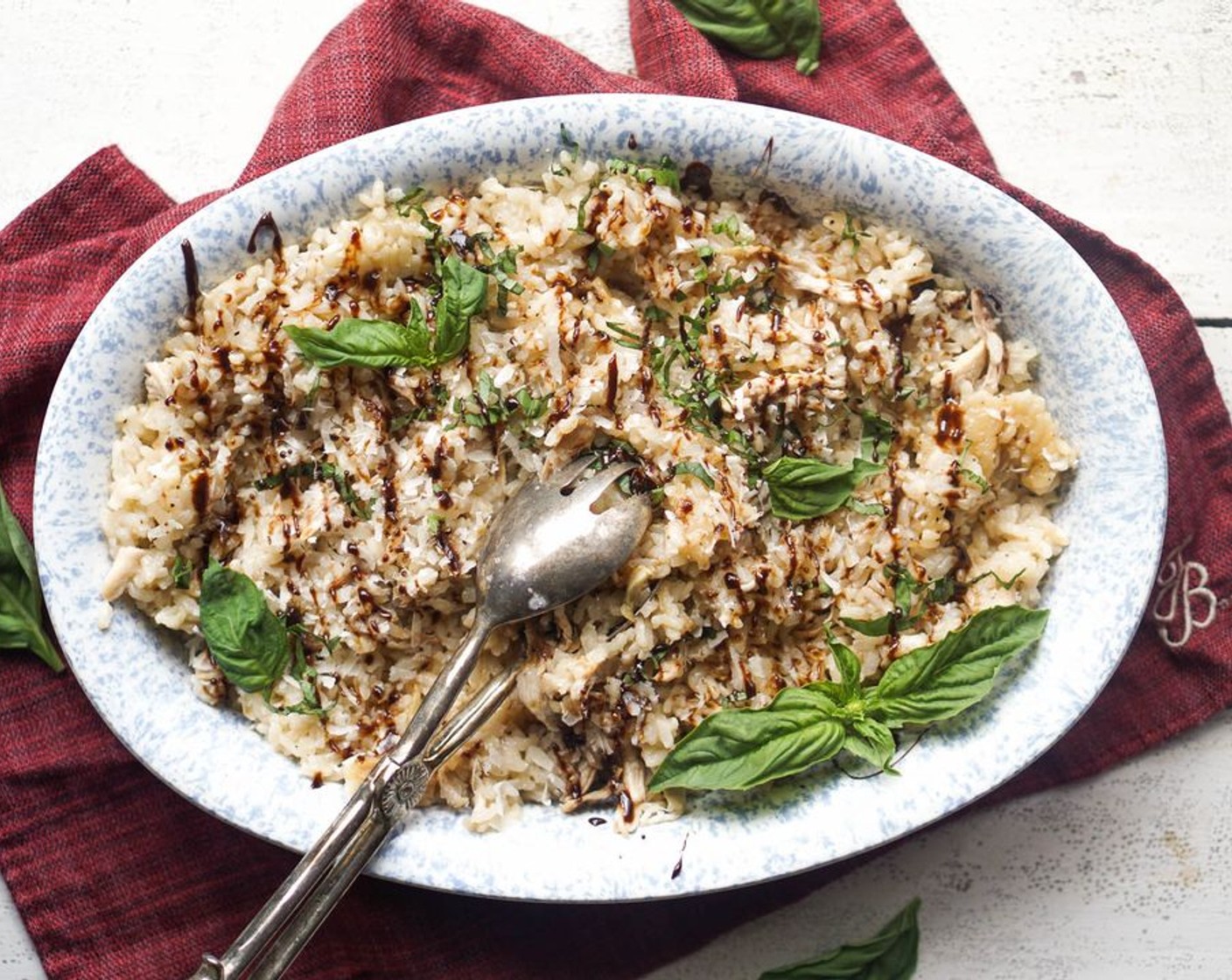 step 10 Once the risotto is done, toss in the shredded chicken, squeeze out the roasted garlic, and top with Parmigiano-Reggiano (to taste), Fresh Basil Leaves (4), and balsamic reduction.