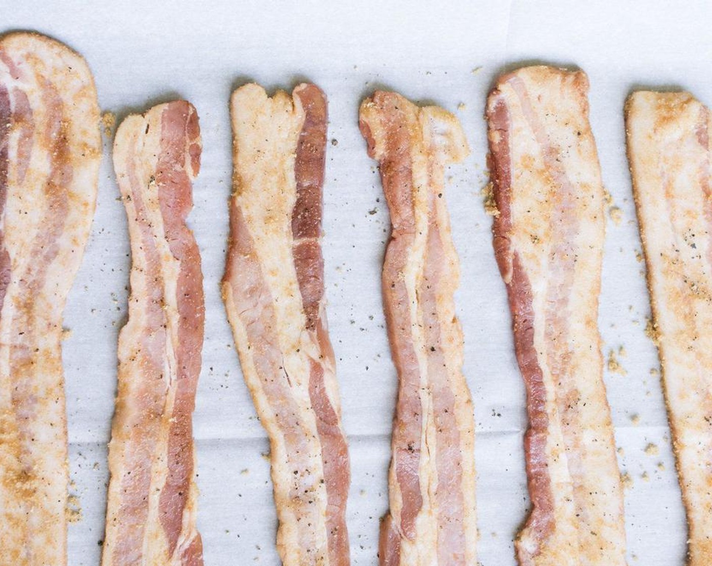 step 4 Lay out bacon strips on parchment paper on baking sheet.