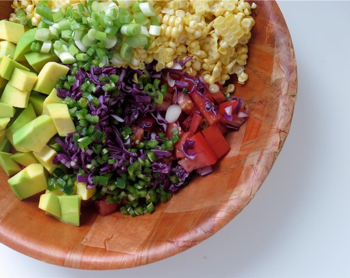 step 3 In a large bowl, combine Corn (1 1/2 cups), red cabbage, serrano peppers, scallions, red bell pepper, medium tomato, and florida avocado. Toss to combine.
