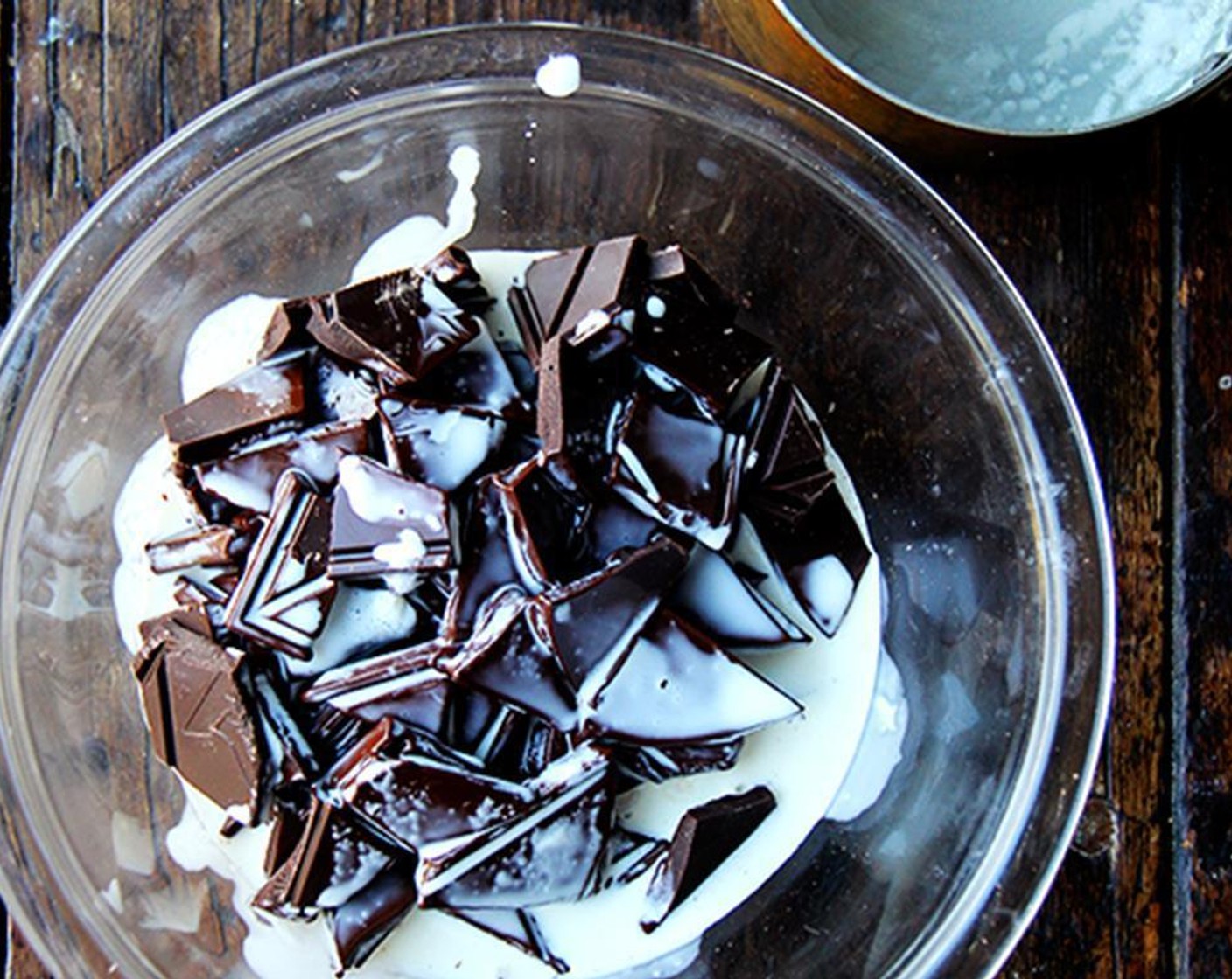 step 2 Bring Heavy Cream (1/2 cup) to a boil, keeping an eye on it constantly. Break Bittersweet Chocolate (2 3/4 cups) into small chunks and place in heat-safe bowl. Pour cream over chocolate, push chocolate chunks down with a spatula so they are submerged, and let sit for a minute.