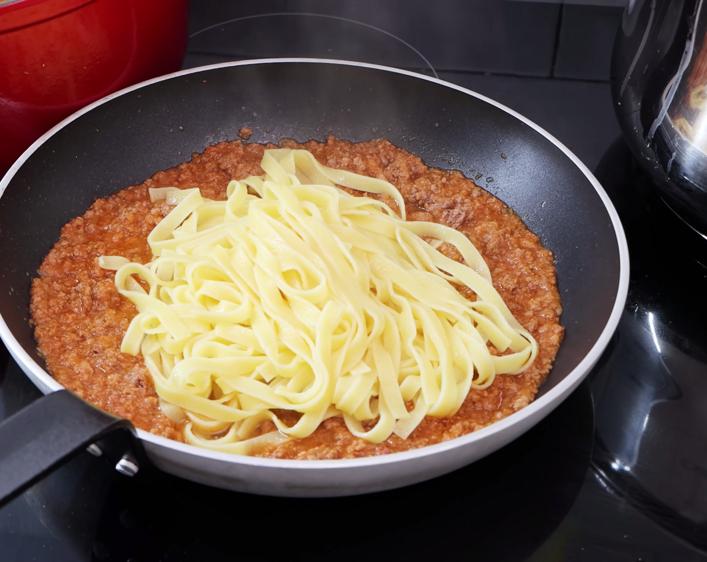 step 14 Next, add the strained pasta into the pan along with 2 spoonfuls of pasta water.