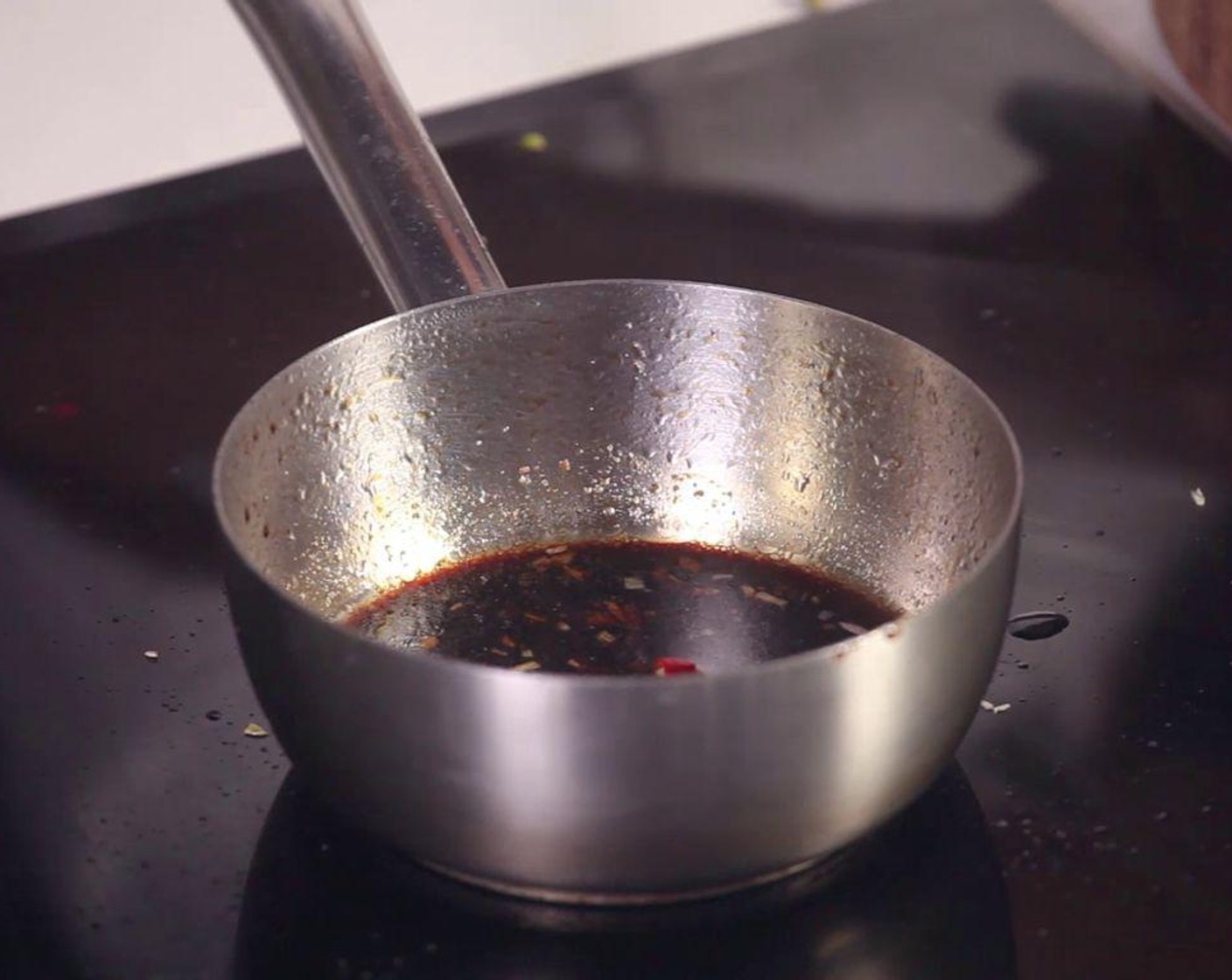 step 4 Use a small pot to prepare the sauce: Sauté Garlic (1 clove), Red Chili Pepper (1), and Long Green Peppers (1/2) in hot Cooking Oil (1 tsp).