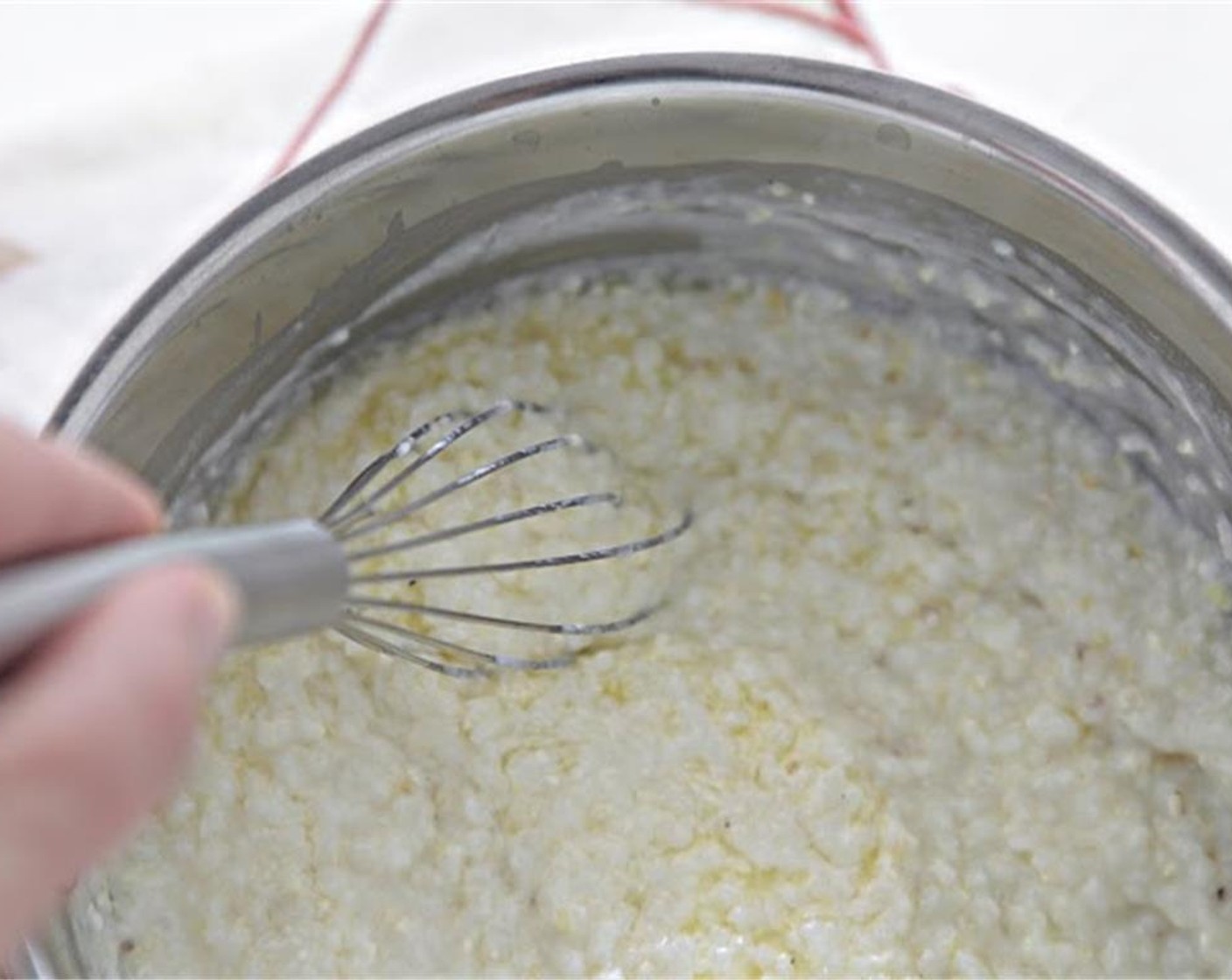 step 1 To begin, place a medium size saucepot over high heat. Add Water (3 1/2 cups), Garlic (4 cloves), and Kosher Salt (to taste). Bring the water to a boil, and add the Polenta Grits (1 cup), slowly, whisking the entire time.