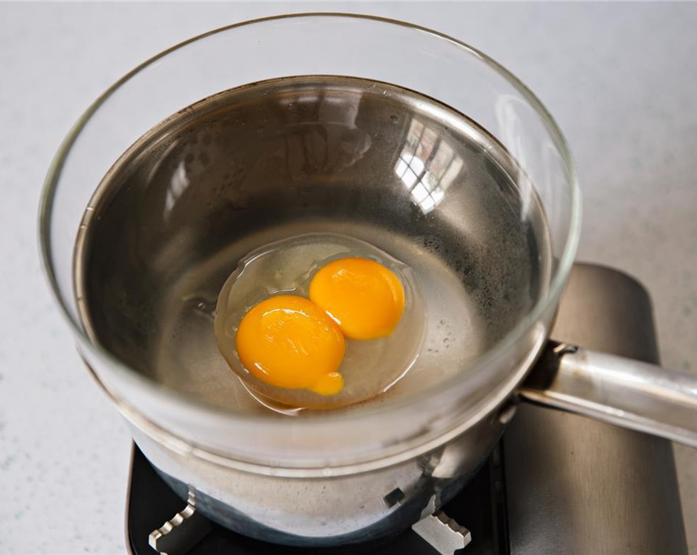 step 5 Place bowl with egg yolks on top of saucepan.