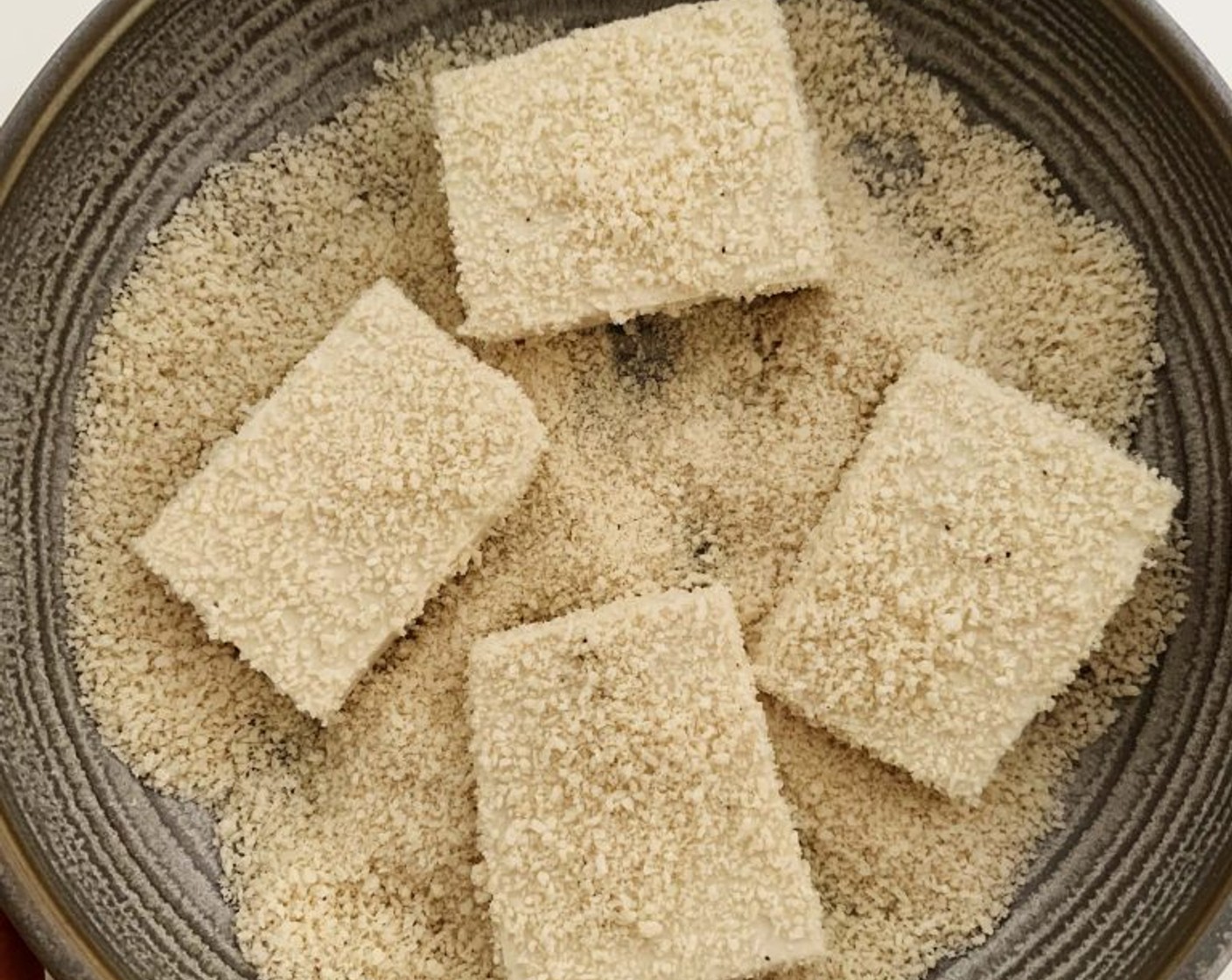 step 3 Then, place the Tofu into the bowl of the breadcrumb mixture and coat evenly on both sides.