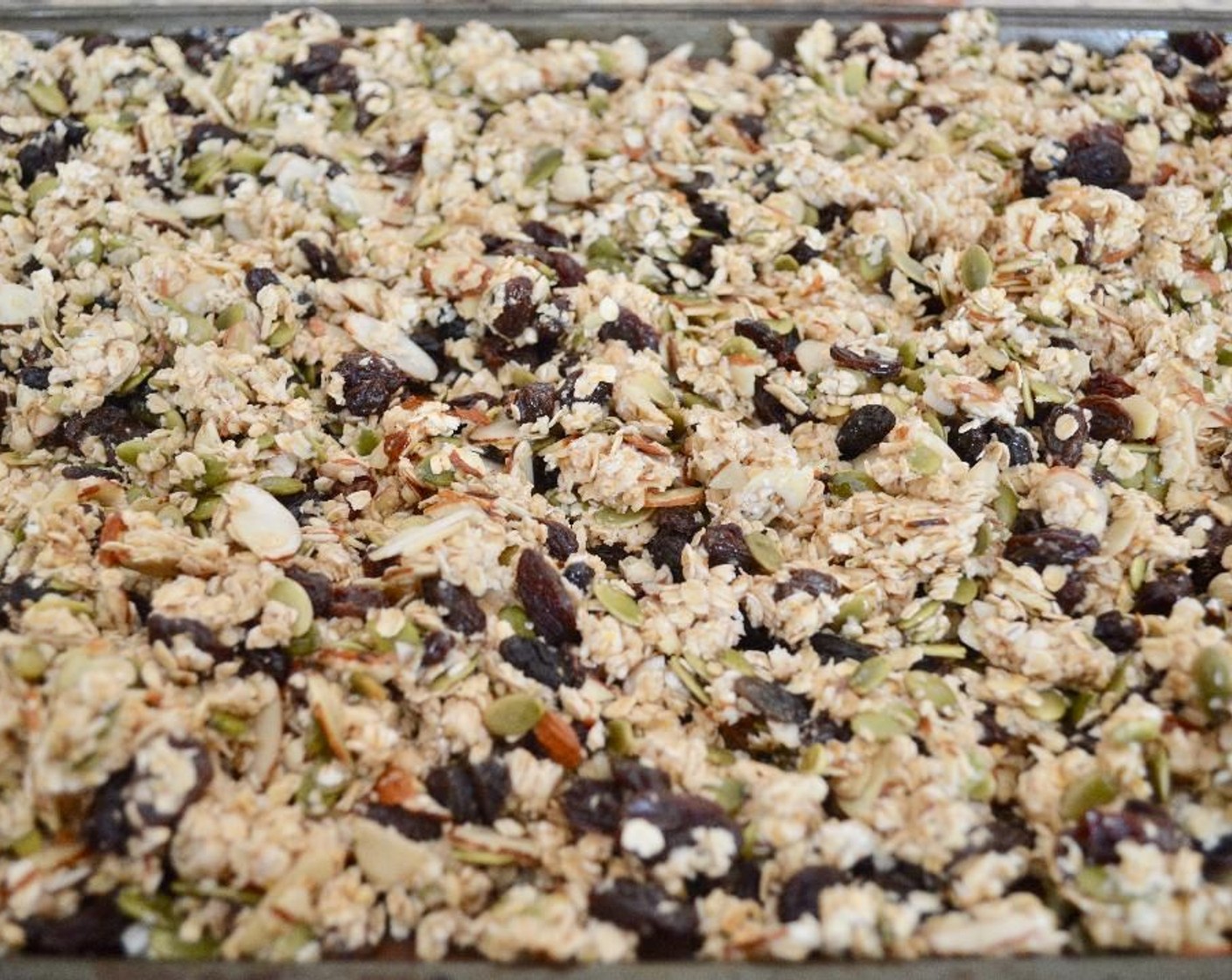 step 2 Place the Quick Cooking Oats (3 cups), Sun-Maid Raisins (2 cups), Slivered Almonds (1 cup), Pepitas (1 cup), zest and juice from Lemons (5), Ground Lavender (1 tsp), Lavender Extract (1/2 tsp), and Lavender Infused Honey (3/4 cup) in a large mixing bowl. Stir it all together thoroughly. Turn it out onto the sheet tray and spread it out evenly.