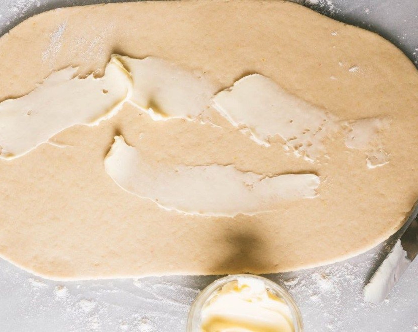 step 7 On a well-floured surface, roll out the dough into a 10×14 inch rectangle. Spread with Butter (4 Tbsp) and sprinkle with the sugar mixture until the entire surface is covered.
