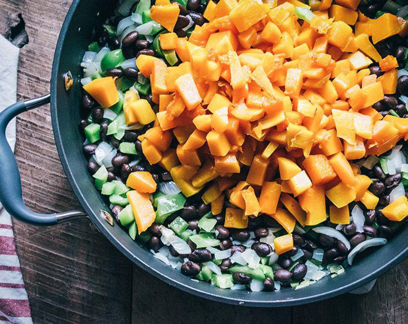 step 3 Meanwhile add Coconut Oil (1 Tbsp), Onion (1), Green Bell Pepper (1), Garlic (2 cloves) to large sauce pan, and cook over medium heat for 5-7 minutes or until onions are translucent, add in Canned Black Beans (2 1/3 cups) and cooked butternut squash, stir to combine.