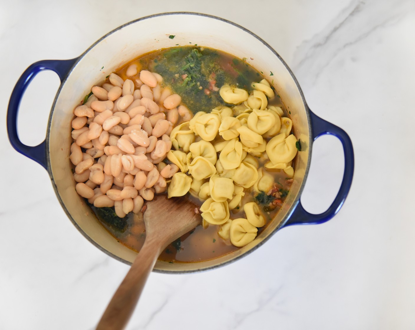 step 5 Once the liquid is boiling, turn the heat back down to medium-high. Add in the Cheese Tortellini (1 pckg) and Cannellini White Kidney Beans (1 can). Cover the pot with the lid and simmer for 6 minutes until the tortellini is just cooked.