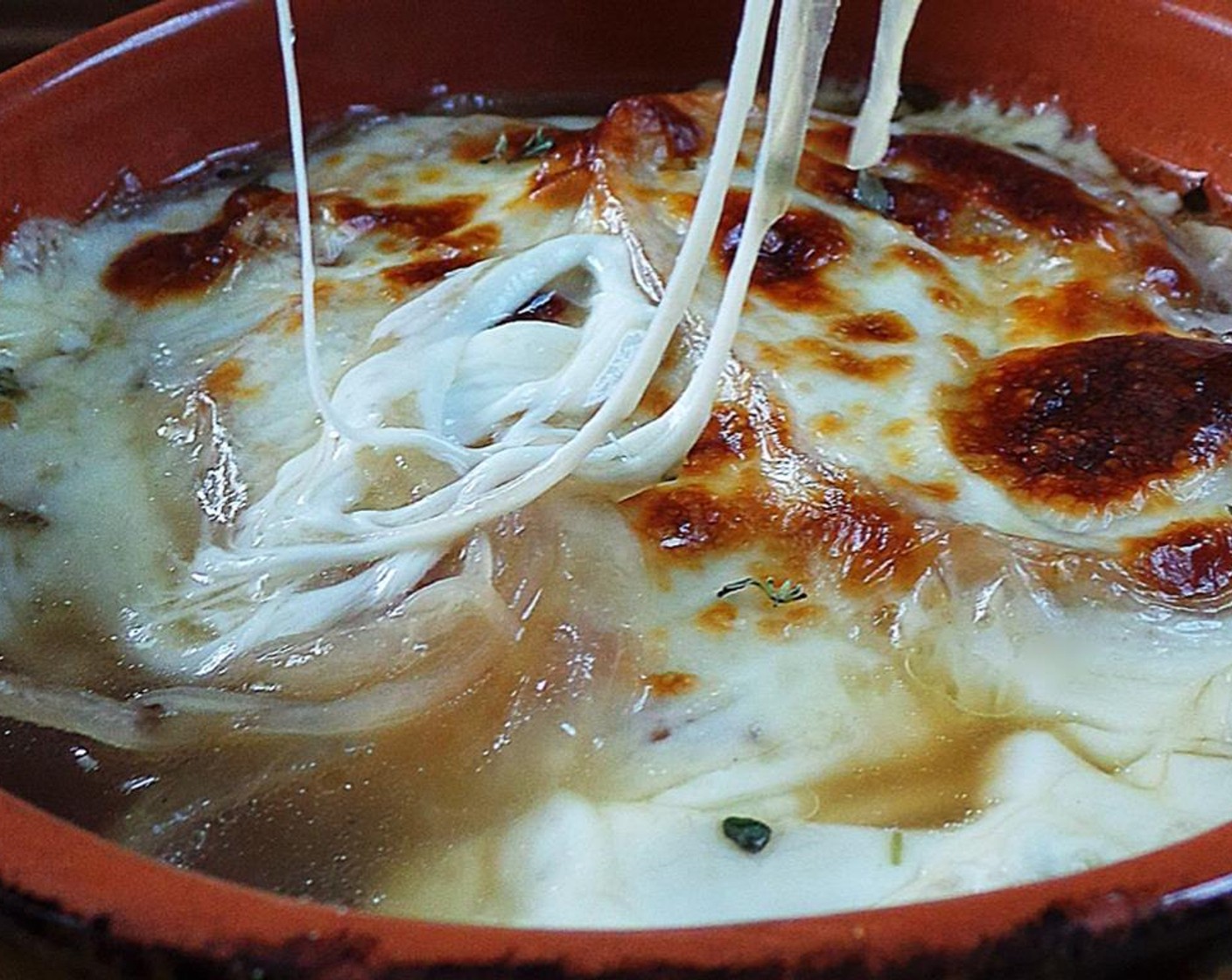 step 7 Portion into soup bowls, add 2 slices of bread, top each bowl with a slice of Provolone Cheese (4 slices), then place under the broiler until cheese is golden brown.