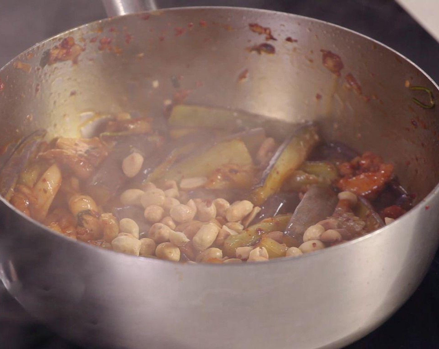 step 3 Prepare a hot pan with Cooking Oil (1 Tbsp), Garlic (2 cloves), Fresh Cilantro (2 sprigs), then add chicken and fried eggplant. Add Vietnamese Spice Blend (1 tsp) and Peanuts (3 Tbsp) and stir to combine.