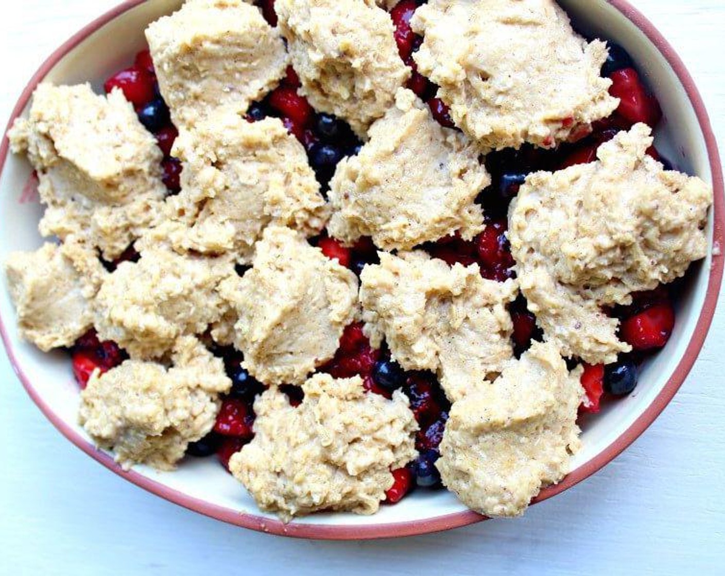 step 5 Dollop the crumble crisp onto the berries with a large spoon, leaving some gaps for air to escape.