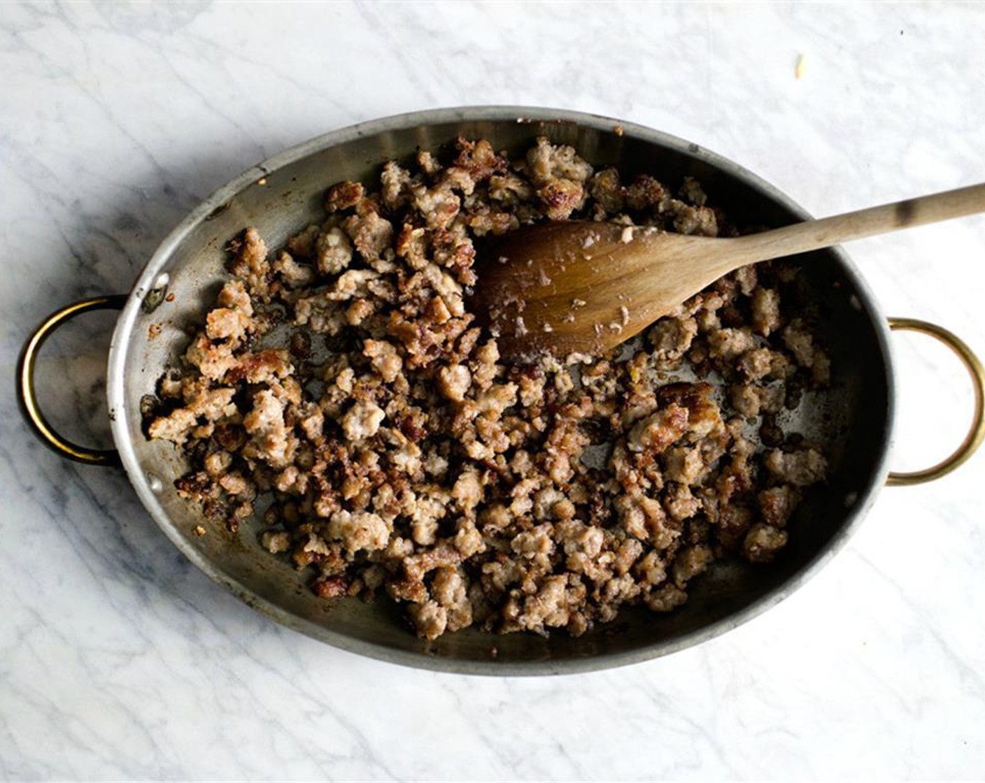 step 11 Heat a large, oven-proof skillet over high heat. Cook the sausage with a bit of vegetable oil, breaking it into small pieces with a wooden spoon, until nicely browned.