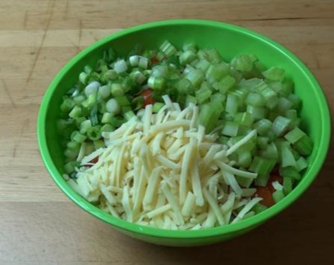 step 2 Add the Cherry Tomatoes (1 2/3 cups), Celery (3 stalks), chopped Scallion (1 bunch), and Cheddar Cheese (1/2 cup) to the bowl. Sprinkle the Olive Oil (1/3 cup) over the mix with the juice from Lemons (1 1/4).