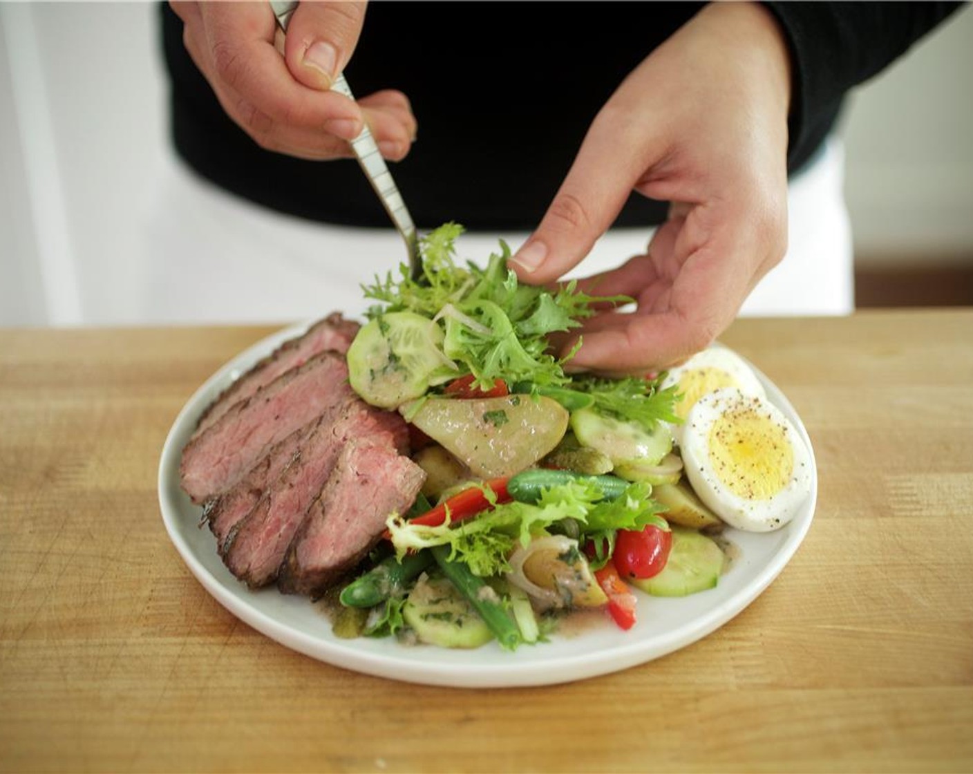 step 24 Evenly divide Curly Endive (3/4 cup) across two plates, and top with flank steak.