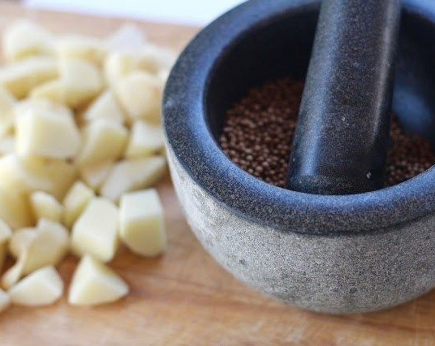 step 3 Use a mortar or a kitchen mallet to roughly crush the Whole Coriander Seeds (1 Tbsp). Add the Olive Oil (4 Tbsp) and coriander seeds to the potatoes and toss to coat.