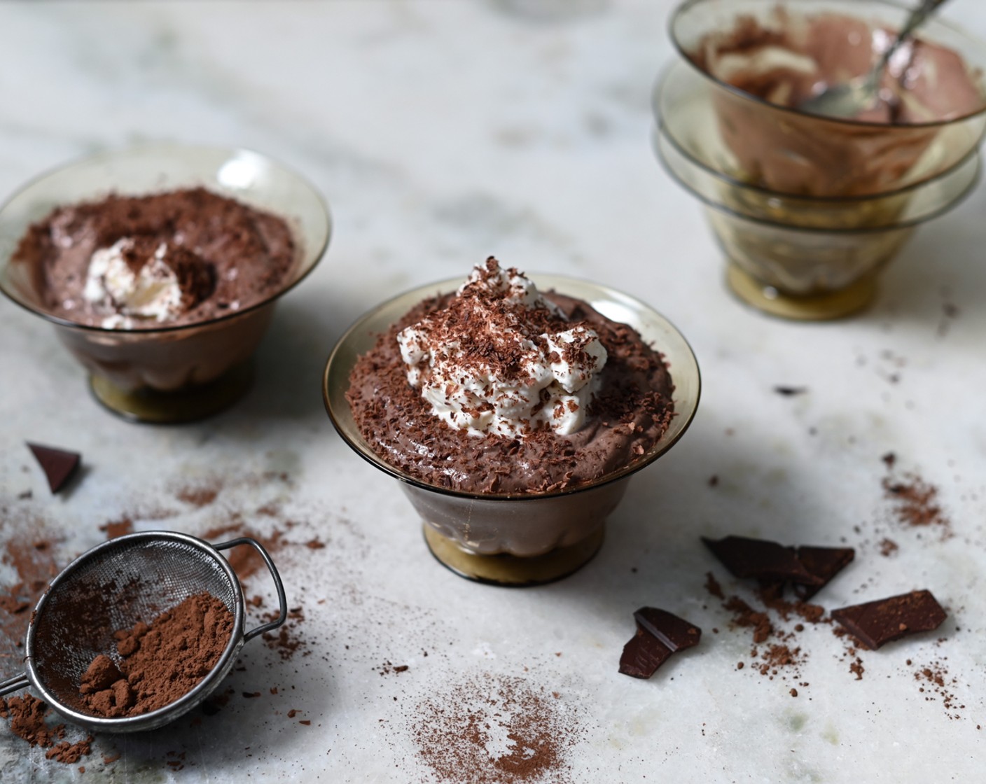 step 8 Prior to serving, whisk the remaining Heavy Cream (3 1/2 Tbsp) to soft peaks and top each mousse with a dollop. Use a fine grater to grate over the reserved chocolate blocks and serve the mousse.