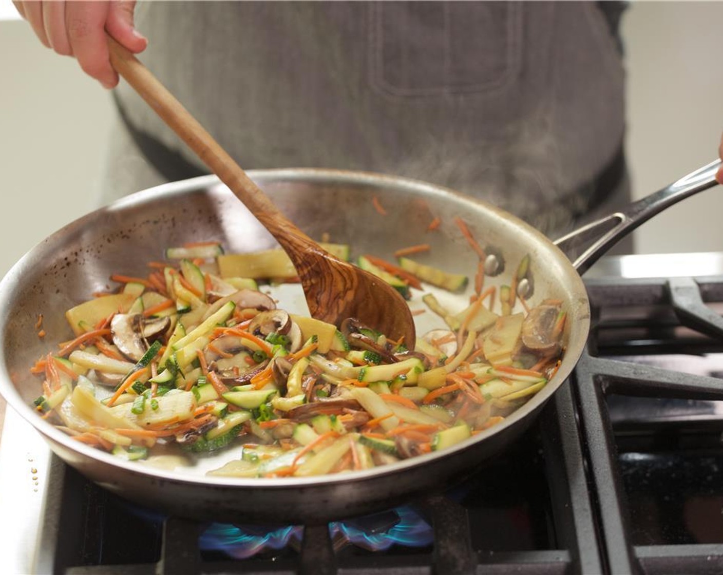 step 5 In a large saute pan over medium heat, add Sesame Oil (2 Tbsp). When hot, add the matchstick carrots and zucchini and cook for 2-3 minutes.