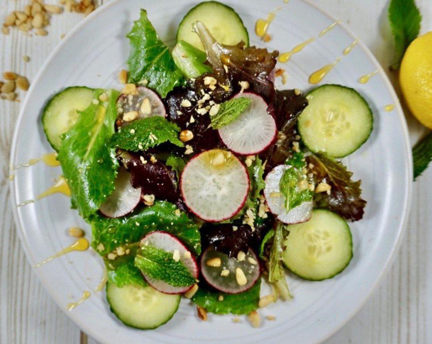 step 3 Remove the radishes and cucumbers from the liquid and nestle them among the greens. Immediately before serving, sprinkle Pine Nuts (1/4 cup) over the salad, drizzle with Honey (1 Tbsp) and top with additional lemon juice and 1 Tbsp zest from the Lemon Zest. Serve and enjoy!