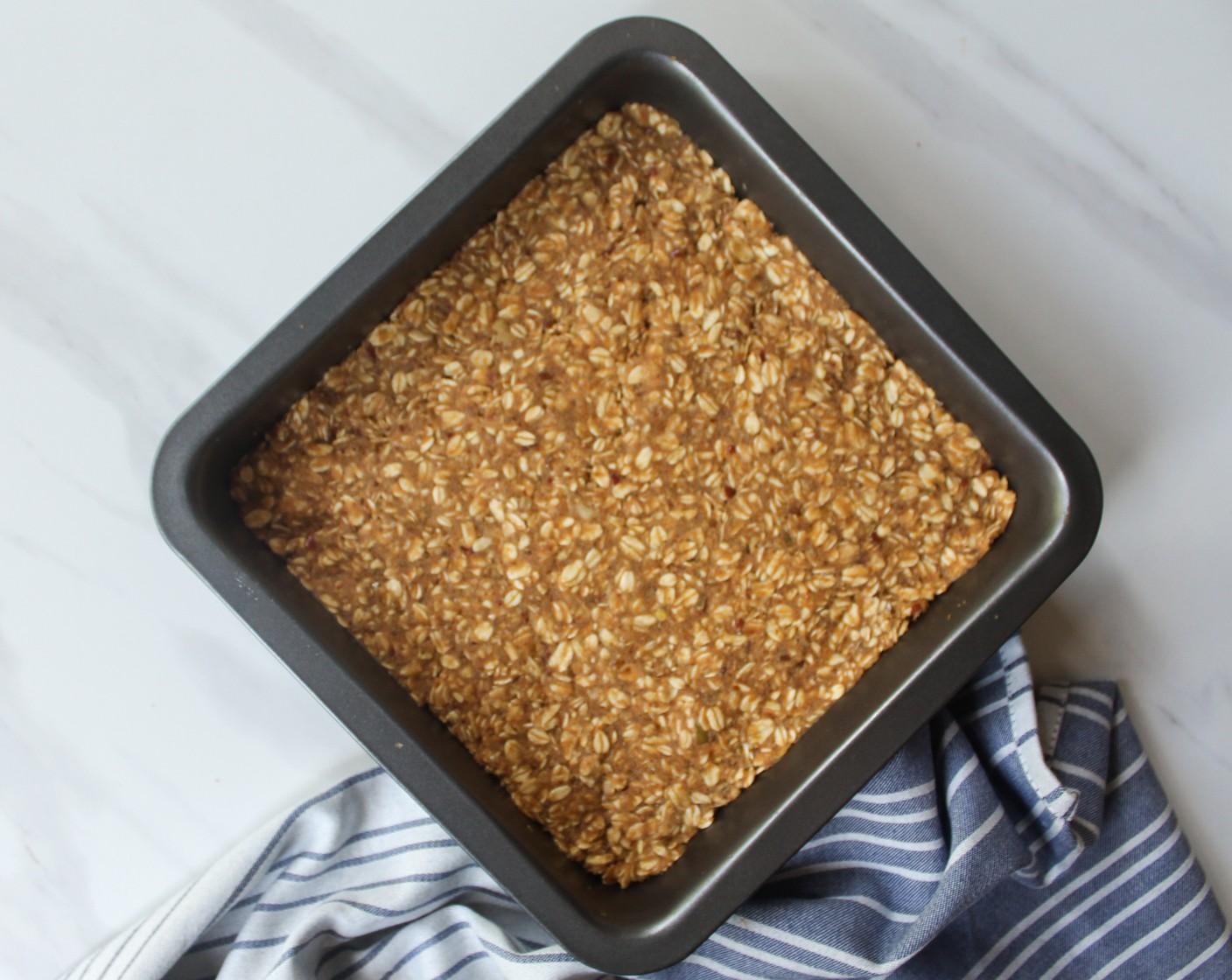 step 6 Transfer the mixture to a lined or greased 8x8-inch baking pan. Using a spatula or the back of a spoon, smooth out the mixture to fit the size of the pan.