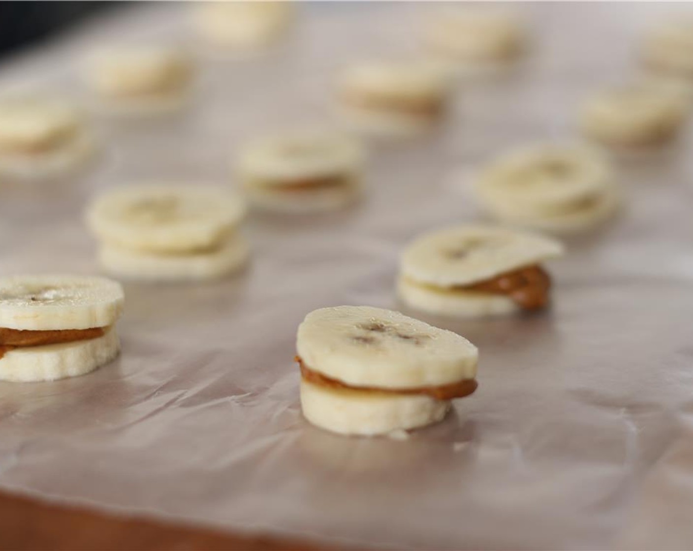 step 3 Top with another slice of banana. Place tray in freezer for half an hour. Eat immediately or put in a tupperware container for snacking!