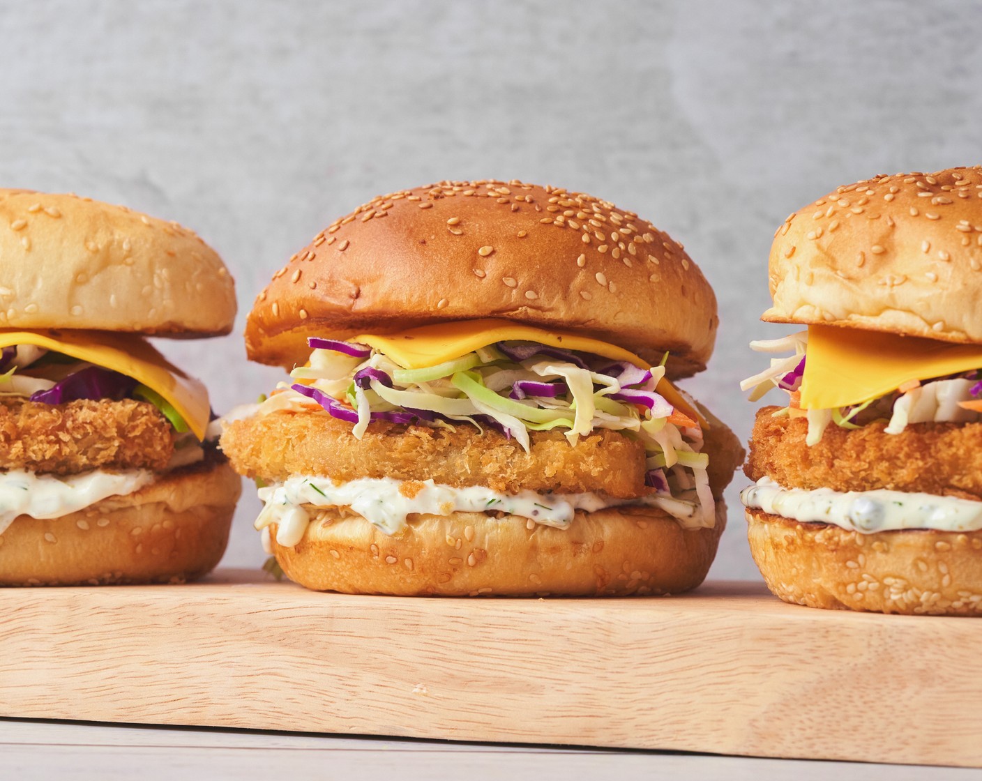 step 4 Stack the fish, Mild Yellow Cheddar (to taste), Tomatoes (to taste), and Coleslaw Mix (to taste) and top with the top bun. Repeat this process on the remaining buns and filets. Serve with fries or salad, and enjoy right away!