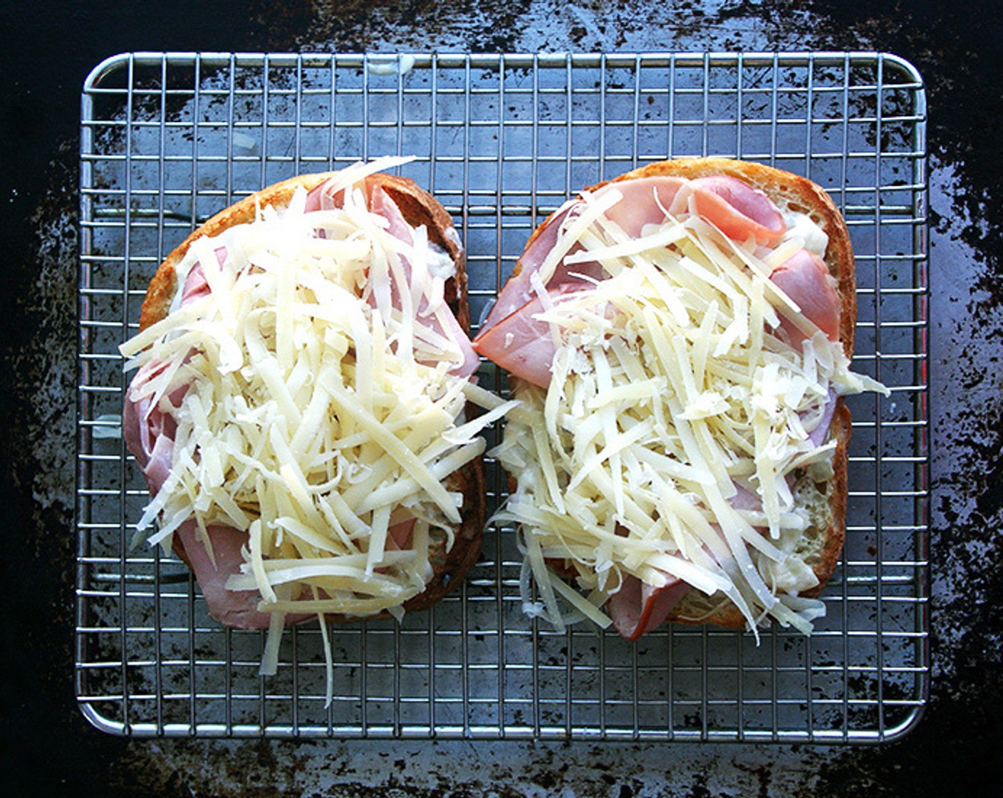 step 9 Spread about 1 tablespoon of béchamel over each slice of bread. Top with Black Forest Ham (4 slices). Top with Gruyère Cheese (to taste). Set aside.
