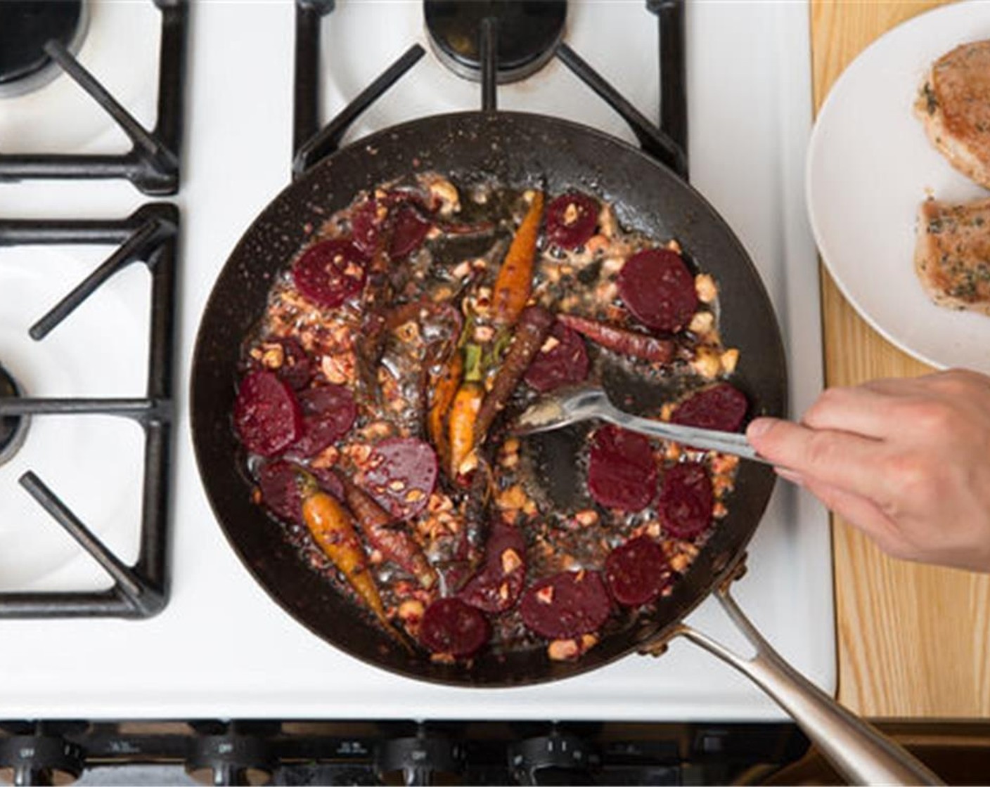 step 10 Add the carrots, Hazelnuts (2 Tbsp), and marinated beets to the pan of reserved fond. Cook on medium heat, stirring occasionally, for 1 to 2 minutes, or until thoroughly combined and warmed through; season with Salt (to taste) and Ground Black Pepper (to taste).