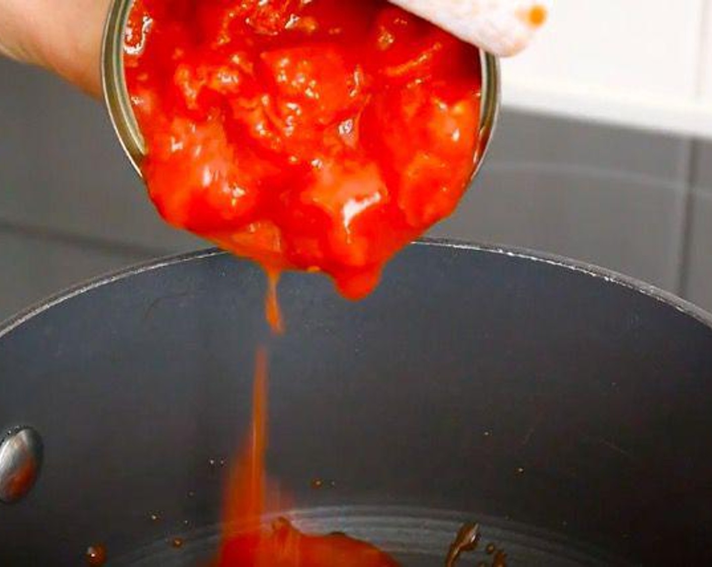 step 2 In a pot add Canned Chopped Tomatoes (2 cups), Dried Oregano (1 tsp), Salt (to taste), Ground Black Pepper (to taste), Sriracha (1 Tbsp), Fresh Basil (1 bunch), Capers (1 Tbsp), and Sunblush® Tomatoes (1 Tbsp). Leave the sauce to cook for about 15 minutes at a low to médium temperature