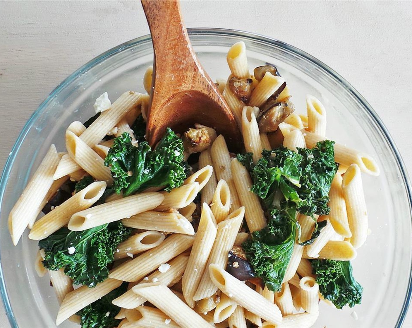 step 8 Once everything's finished, toss the kale/garlic, eggplant, and noodles in a large bowl. Sprinkle with Feta Cheese (to taste) and toasted pine nuts and squeeze over some fresh Lemon (1).