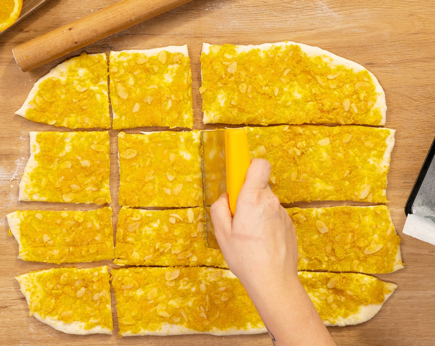 Schritt 5 Die Orangenfüllung gleichmäßig auf dem Teig verteilen. Danach den Teig in gleichgroße Quadrate schneiden.