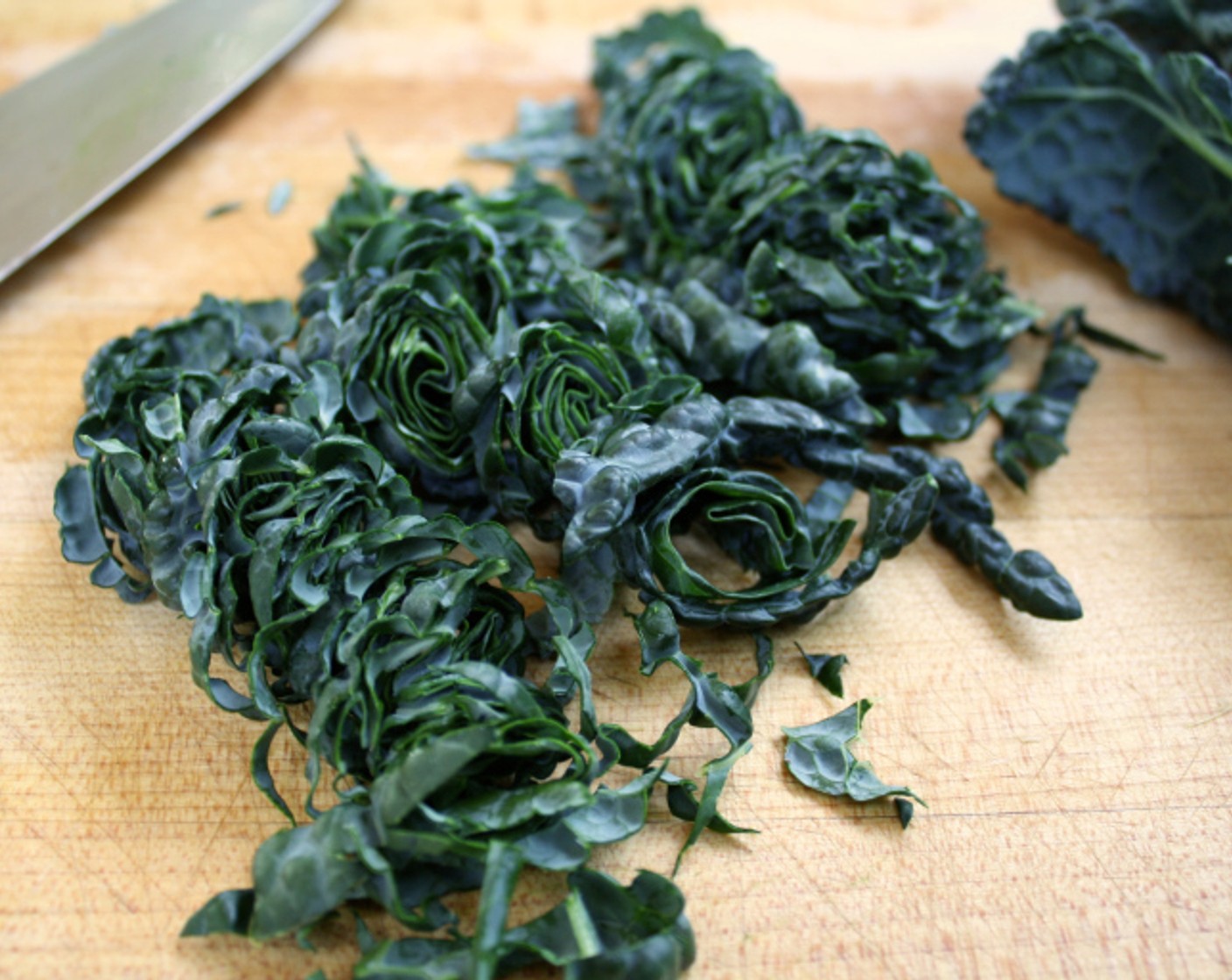 step 6 Meanwhile, chiffonade the Tuscan Kale (3 bunches): cut along each side of the rib to remove the leaves on each side. You should end up with two long strips from each rib.