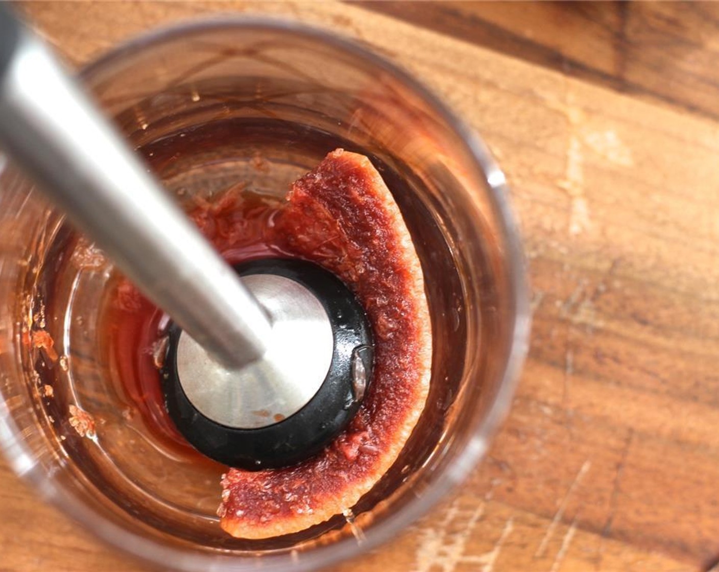 step 2 In a rocks glass, muddle the Brown Sugar Cube (1), Angostura Bitters (6 dashes), and one of the thin grapefruit slices until the sugar is mostly dissolved.