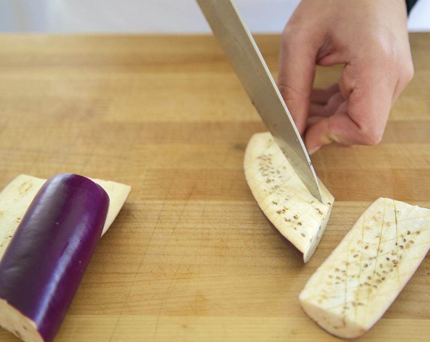 step 2 Cut the Chinese Eggplant (2), in half lengthwise, then across on a bias to create 8 equal size pieces.