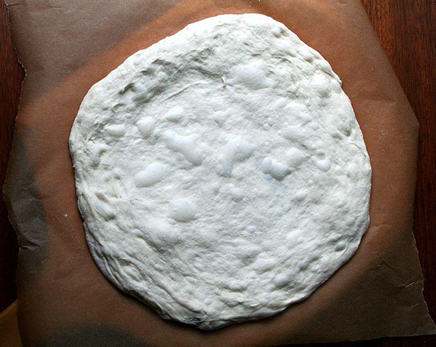 step 6 Pull out a pizza round from the fridge one hour before you plan on baking. Dust dough with flour and place on a floured work surface.
