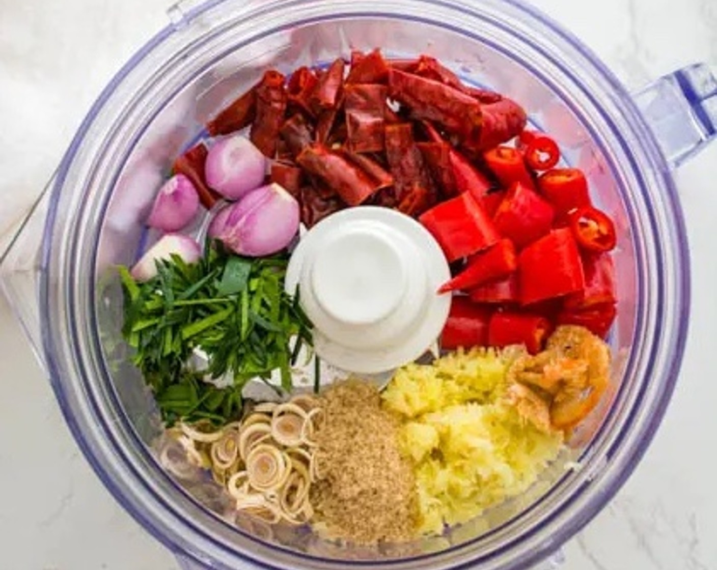 step 4 Pour the tamarind juice into a food processor along with the sliced dried red chili, Red Chili Peppers (3), Lemongrass (3 stalks), Shallots (5), Galangal (1 in), Kaffir Lime Leaves (5), Brown Sugar (2 Tbsp), Coconut Oil (2 Tbsp), Dried Shrimp (1 Tbsp), and Fresh Cilantro Leaf (1 cup).