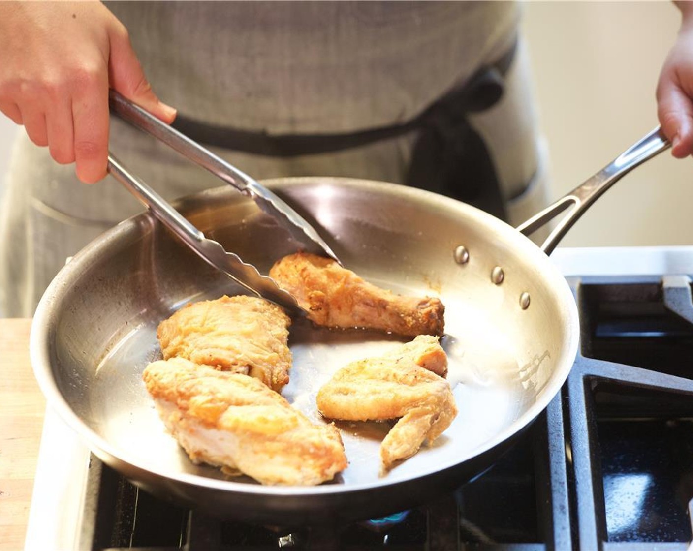step 15 When the oil is hot, carefully add the chicken skin side down, and brown for six minutes.