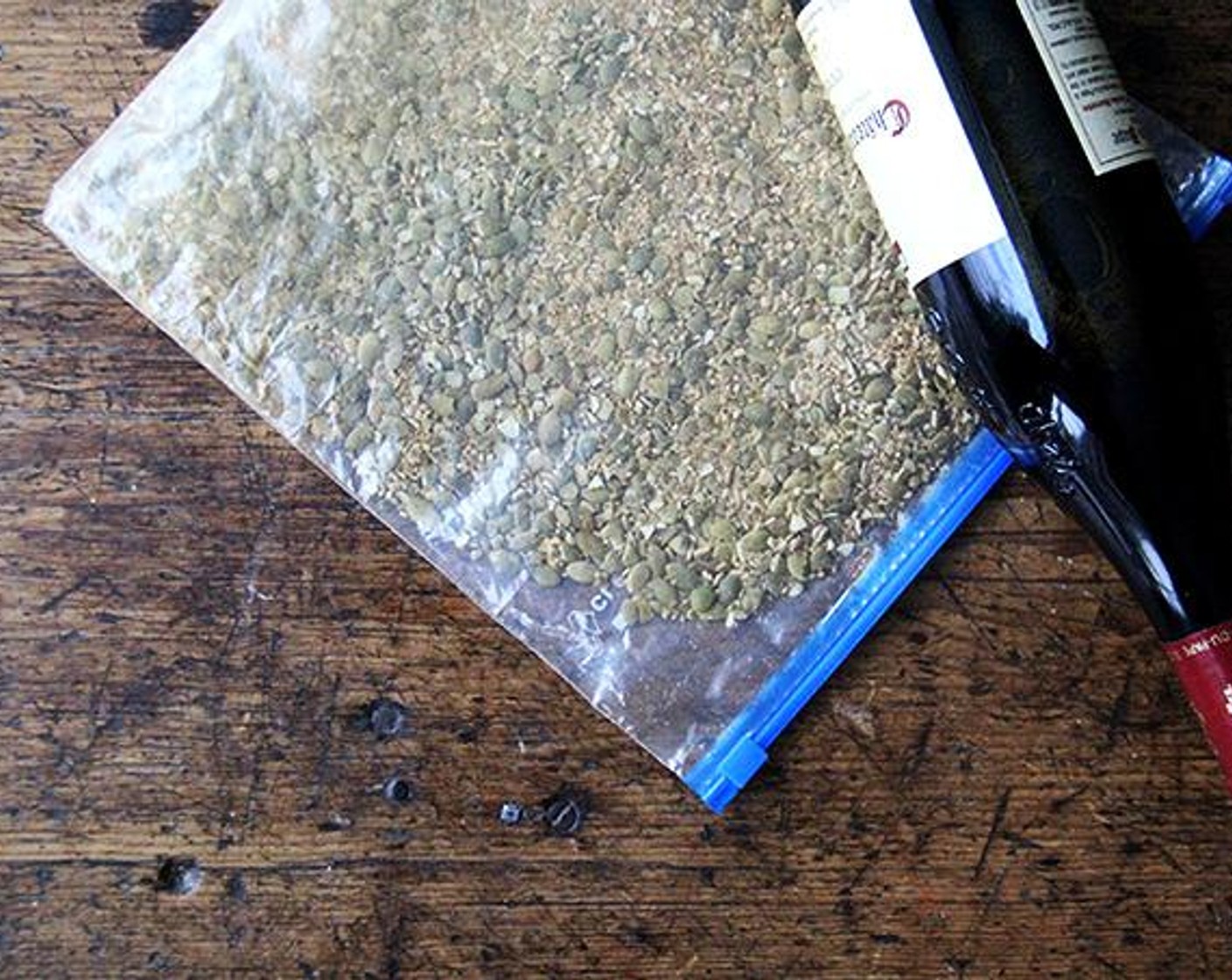 step 6 Place the seeds in a zip-lock bag. Holding a wine bottle by the neck, gently tap the bottom of the bottle against the seeds until they are crushed, but not uniformly fine like bread crumbs. Transfer the seeds to a small rimmed sheet pan or other similar vessel.