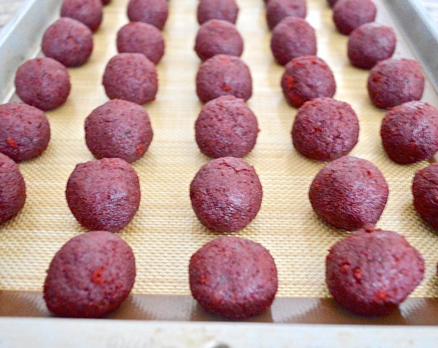 step 5 Get out a sheet tray and line it with either a silicone mat or parchment. Then use a 1 1/2- inch cookie scoop to scoop out perfect portions of the dough and roll them into smooth little balls. Line them up on the tray as you make them, you should get 40 total using that measurement.