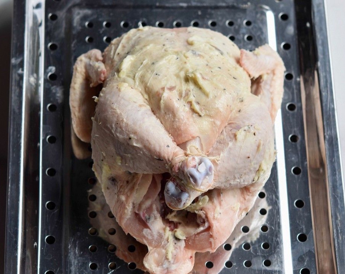 step 4 Using your fingers, rub the anchovy butter all over the chicken. Loosen the skin over the breast and push butter into the pocket as this ensures a juicy roast. Keep a little of the anchovy butter aside to baste the chicken as it cooks.