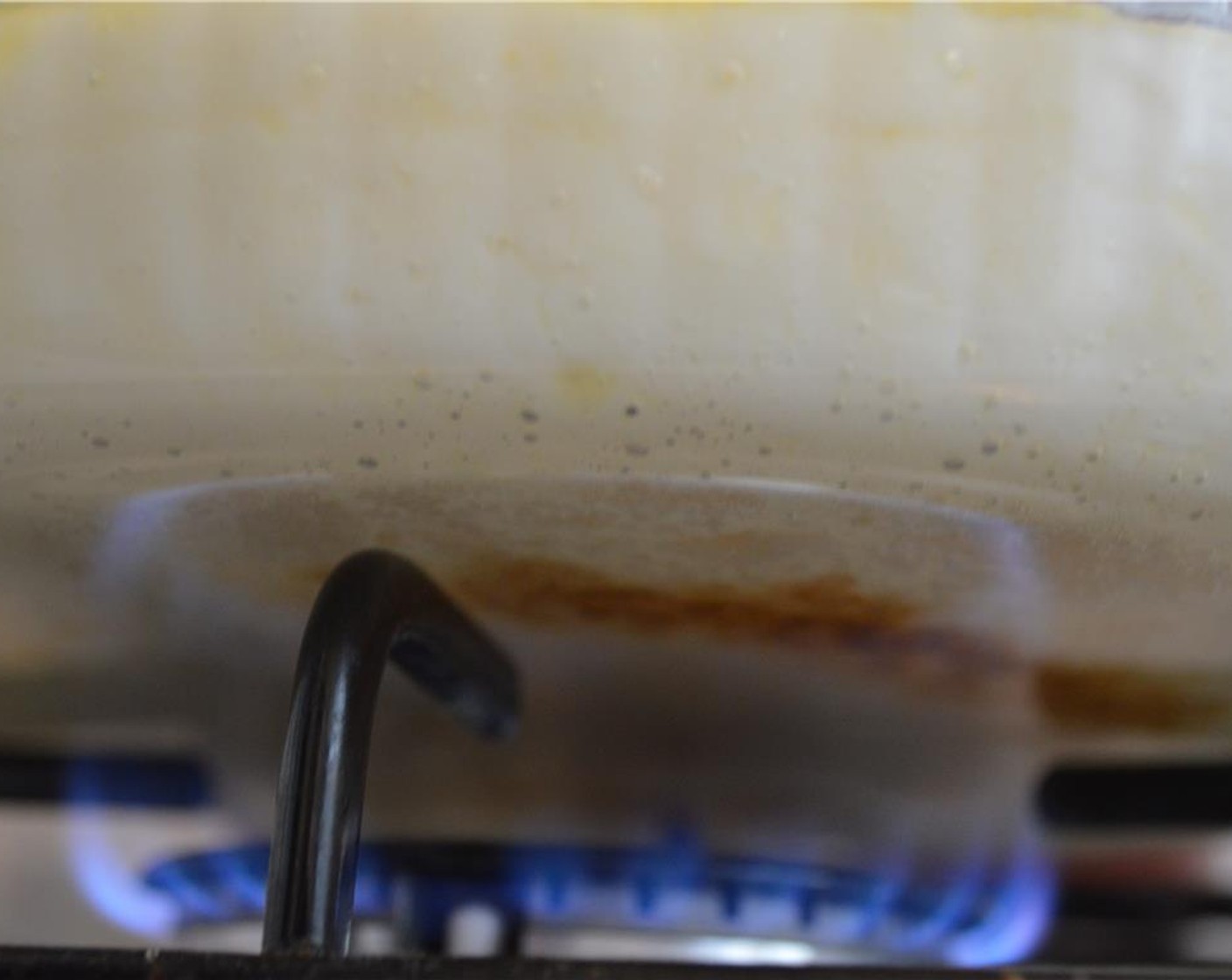 step 5 Now pour the pudding into the prepared glass tray, and set over a low flame. Using oven mitts, move the tray around every minute or so when you see that a part of the bottom of the pudding has become a dark brown.